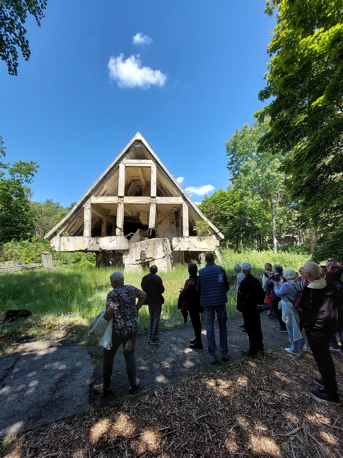 Gruppe der Teilnehmenden steht vor den Ruinen der gesprengten Häuser der Bunkerstadt Wünsdorf