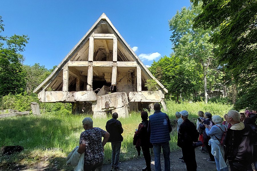 Gruppe der Teilnehmenden steht vor den Ruinen der gesprengten Häuser der Bunkerstadt Wünsdorf